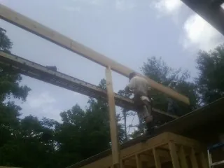 Carpenter setting a ridge beam over a new addition frame — Ice Dam Removal by Roofing Brothers in Wellersburg