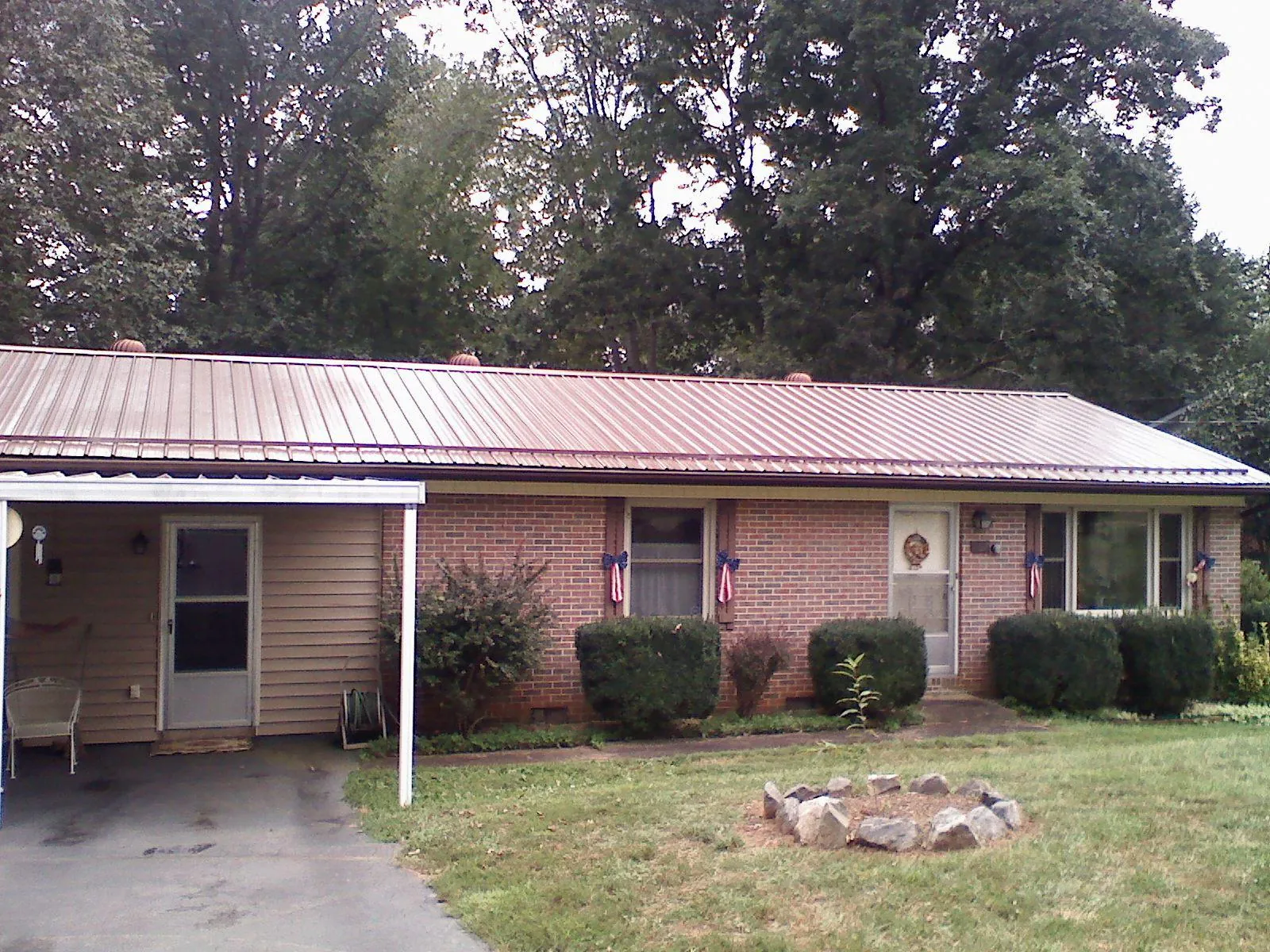 Bronze metal roof and carport on a brick ranch home — Roof Repair work by our crew in Wellersburg